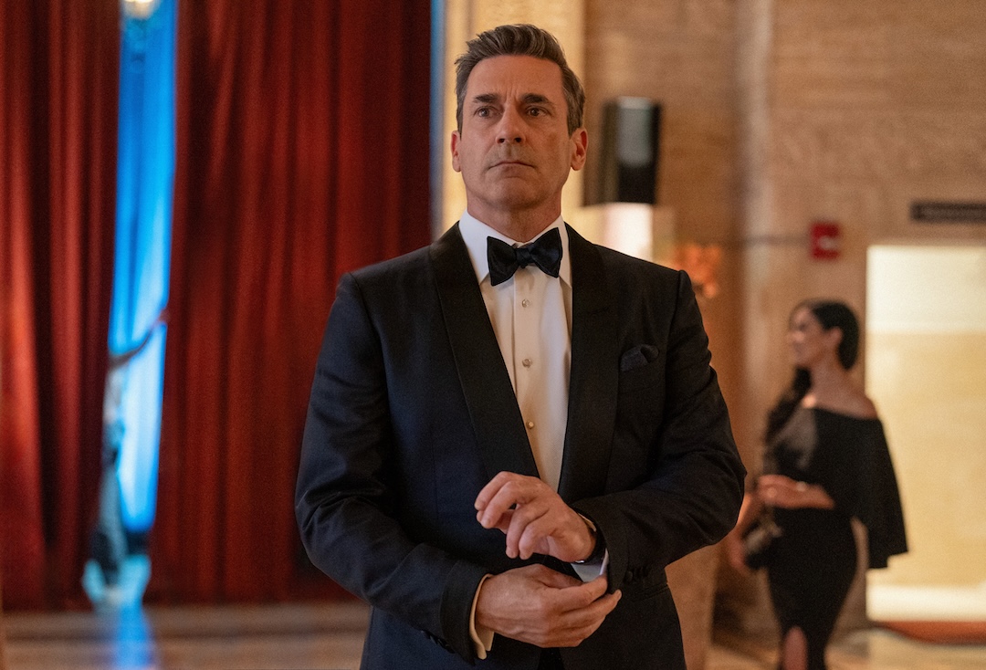 Jon Hamm, as Coop, fidgets with his tuxedo's cufflinks as he looks anxiously in front of him, facing the camera.